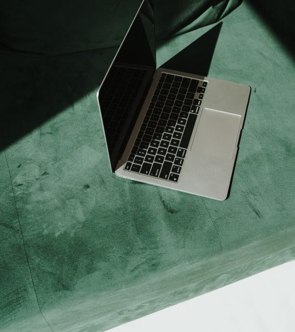 laptop on green suede couch bespoke-social-co-social-media-management-and-strategy-services